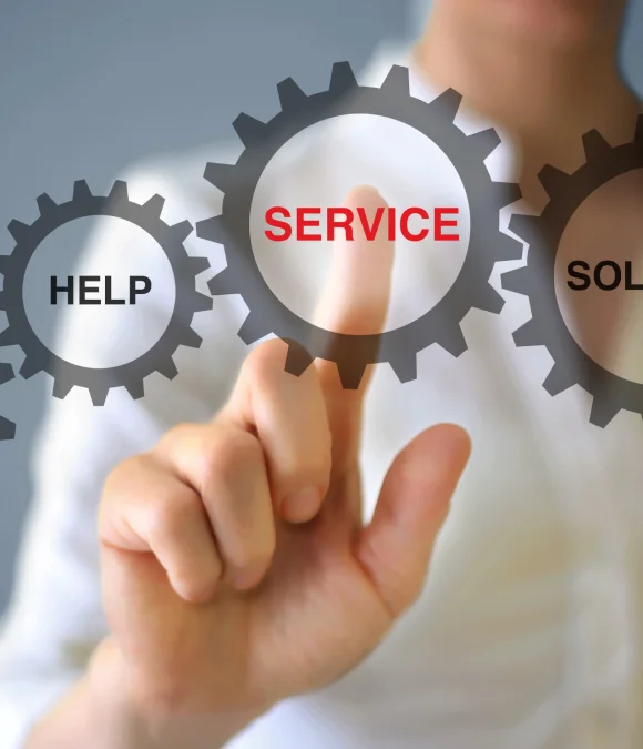 A close-up of a person's finger touching a digital interface with three interlocking gears. The finger is pointed at the central gear, which contains the word "SERVICE" in red letters. To the left is a smaller gear with the word "HELP," and to the right is a partially visible gear.