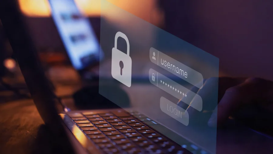It features a close-up of a laptop with a transparent digital login interface layered on top. This interface prominently displays a padlock icon, symbolizing security, alongside fields for a username and a password (hidden by asterisks).